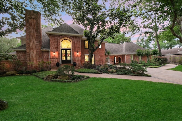 513 Rancho Bauer Dr, Houston, TX 77079 - traditional home with french doors, a chimney, curved driveway, a front lawn, and brick siding