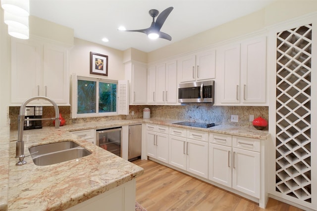 513 Rancho Bauer Dr, Houston, TX 77079 - kitchen featuring stainless steel microwave, wine cooler, a sink, white cabinetry, and recessed lighting
