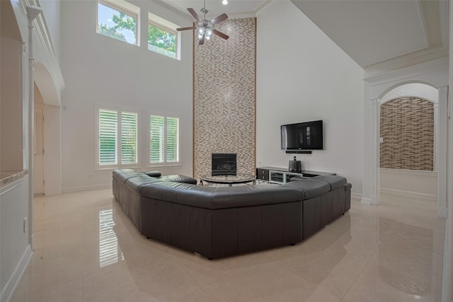 5411 Oban Terrace Ln, Sugar Land, TX 77479 - living area featuring a towering ceiling, a ceiling fan, light tile patterned flooring, baseboards, and a fireplace