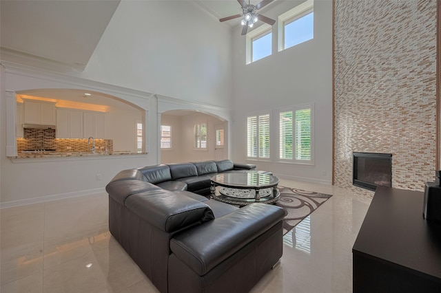 5411 Oban Terrace Ln, Sugar Land, TX 77479 - living area with a high ceiling, light tile patterned floors, a ceiling fan, baseboards, and a fireplace