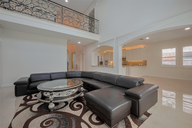 5411 Oban Terrace Ln, Sugar Land, TX 77479 - living room featuring arched walkways, light tile patterned floors, a high ceiling, recessed lighting, and baseboards
