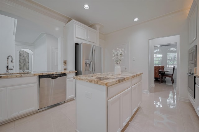 5411 Oban Terrace Ln, Sugar Land, TX 77479 - kitchen with stainless steel appliances, a sink, crown molding, light tile patterned flooring, and light stone countertops
