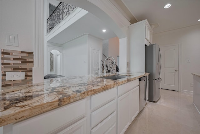 5411 Oban Terrace Ln, Sugar Land, TX 77479 - kitchen with appliances with stainless steel finishes, arched walkways, a sink, light stone countertops, and recessed lighting