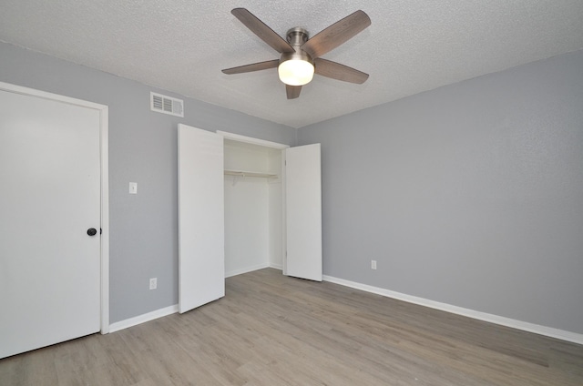 1516 Bay Area Blvd Unit C6, Houston, TX 77058 - unfurnished bedroom featuring light wood-type flooring, a textured ceiling, a closet, baseboards, and ceiling fan