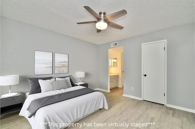1516 Bay Area Blvd Unit C6, Houston, TX 77058 - bedroom with light wood-style floors, a textured ceiling, baseboards, ensuite bathroom, and ceiling fan