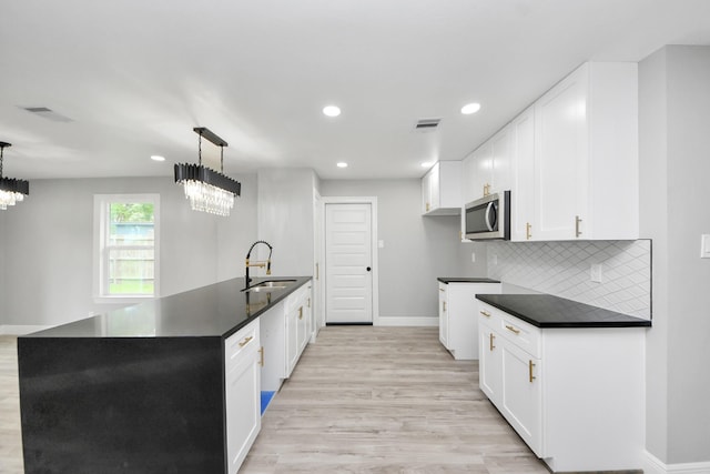 7622 Parker Rd, Houston, TX 77016 - kitchen featuring a sink, dark countertops, stainless steel microwave, baseboards, and recessed lighting