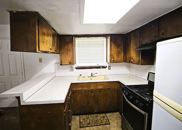 6315 Mardale Dr, Houston, TX 77016 - kitchen with black gas stove, white refrigerator, a sink, light countertops, and a peninsula