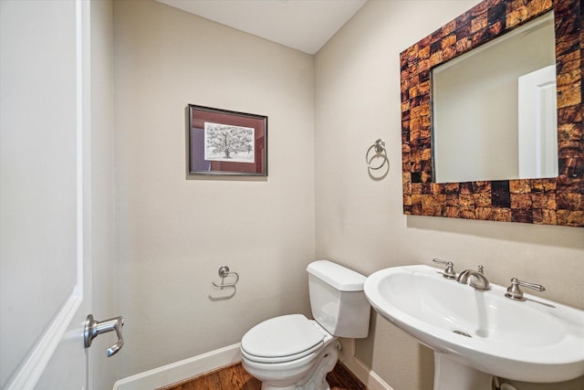 574 Bomar St, Houston, TX 77006 - half bath with a sink, wood finished floors, toilet, and baseboards