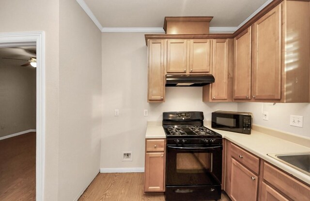 5323 Menard Ave, Galveston, TX 77551 - kitchen featuring black appliances, under cabinet range hood, light wood-style floors, crown molding, and a ceiling fan