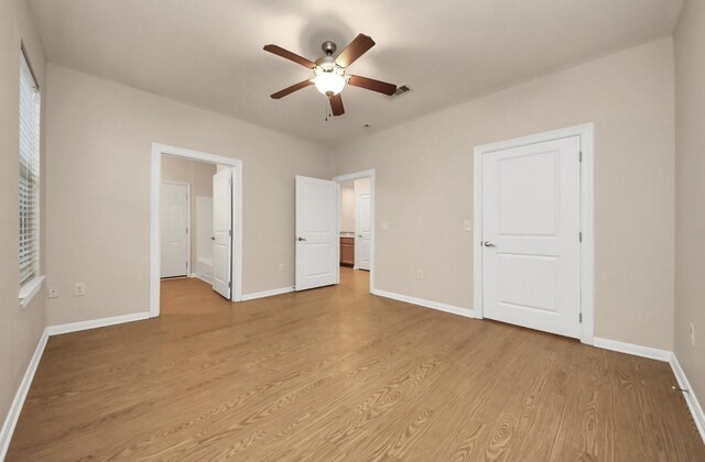 5323 Menard Ave, Galveston, TX 77551 - unfurnished bedroom with light wood-style flooring, baseboards, and a ceiling fan