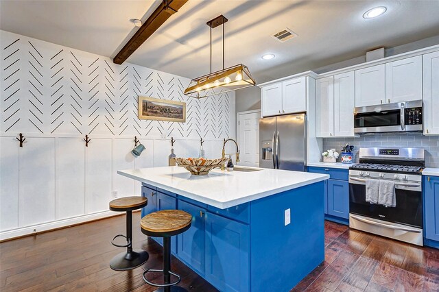 3108 Rogers St, Houston, TX 77022 - kitchen featuring stainless steel appliances, a sink, blue cabinets, light countertops, and a kitchen breakfast bar