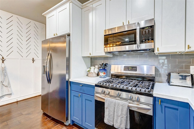 3108 Rogers St, Houston, TX 77022 - kitchen featuring stainless steel appliances, blue cabinets, light countertops, and dark wood-style flooring