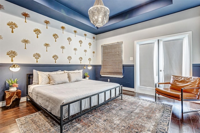3108 Rogers St, Houston, TX 77022 - bedroom with hardwood / wood-style flooring, wainscoting, baseboards, a chandelier, and a raised ceiling