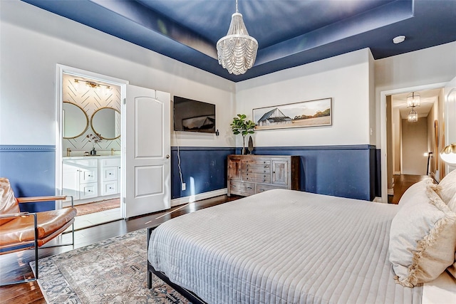 3108 Rogers St, Houston, TX 77022 - bedroom with a chandelier, a raised ceiling, wood finished floors, and ensuite bath