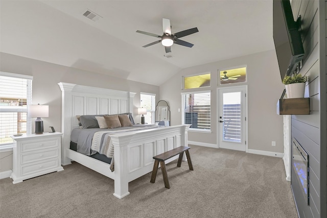 10718 Winding Green Dr, Humble, TX 77338 - bedroom with light carpet, multiple windows, vaulted ceiling, baseboards, and access to outside