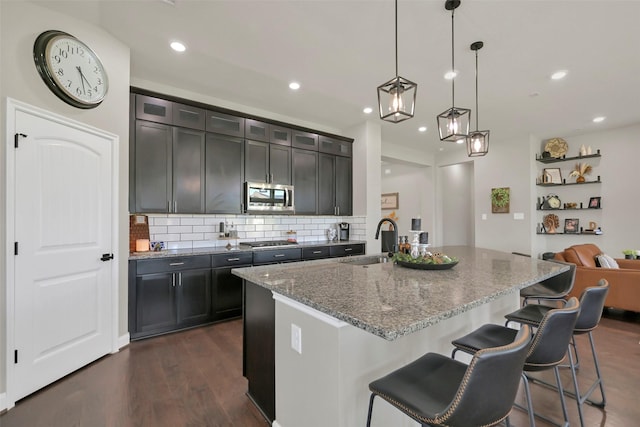 10718 Winding Green Dr, Humble, TX 77338 - kitchen featuring stainless steel appliances, a sink, light stone countertops, a breakfast bar area, and recessed lighting