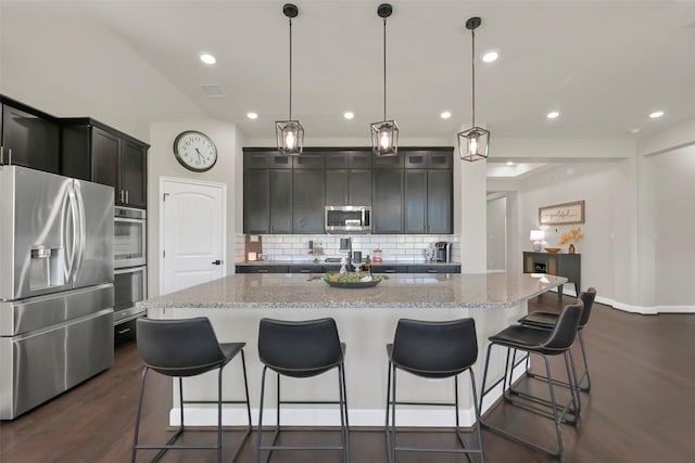 10718 Winding Green Dr, Humble, TX 77338 - kitchen with stainless steel appliances, decorative backsplash, dark wood-style flooring, light stone countertops, and recessed lighting