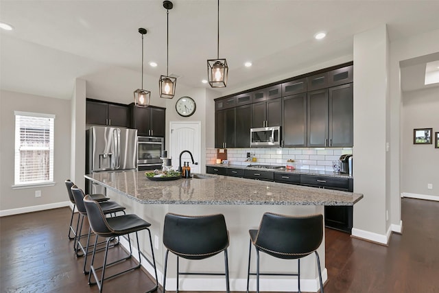 10718 Winding Green Dr, Humble, TX 77338 - kitchen featuring stainless steel appliances, a sink, baseboards, backsplash, and recessed lighting