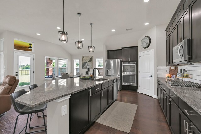 10718 Winding Green Dr, Humble, TX 77338 - kitchen with stainless steel appliances, a sink, open floor plan, light stone counters, and decorative backsplash