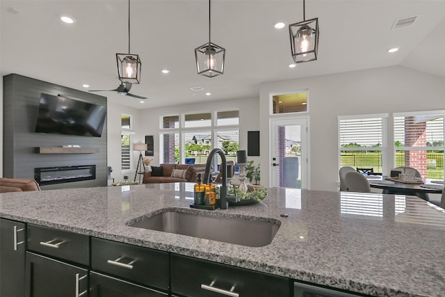 10718 Winding Green Dr, Humble, TX 77338 - kitchen with a sink, open floor plan, recessed lighting, hanging light fixtures, and a glass covered fireplace