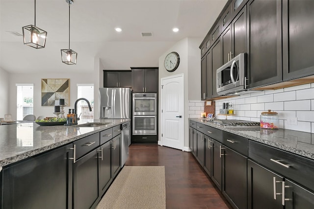 10718 Winding Green Dr, Humble, TX 77338 - kitchen with a sink, appliances with stainless steel finishes, stone countertops, backsplash, and dark wood-type flooring