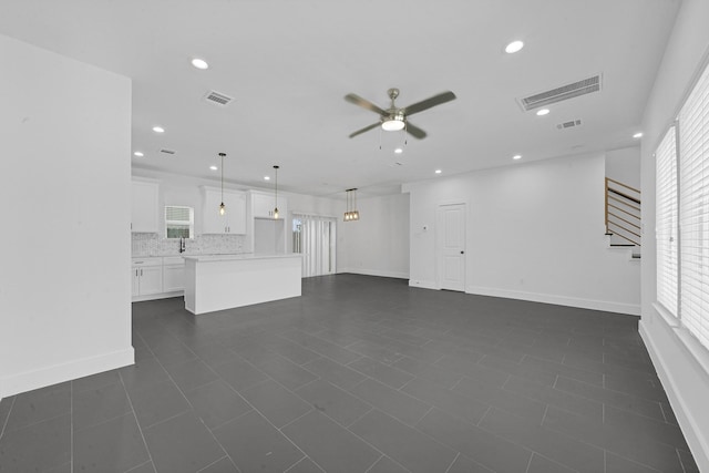 1515 Egypt St, Houston, TX 77009 - unfurnished living room with a ceiling fan, recessed lighting, baseboards, stairway, and dark tile patterned flooring