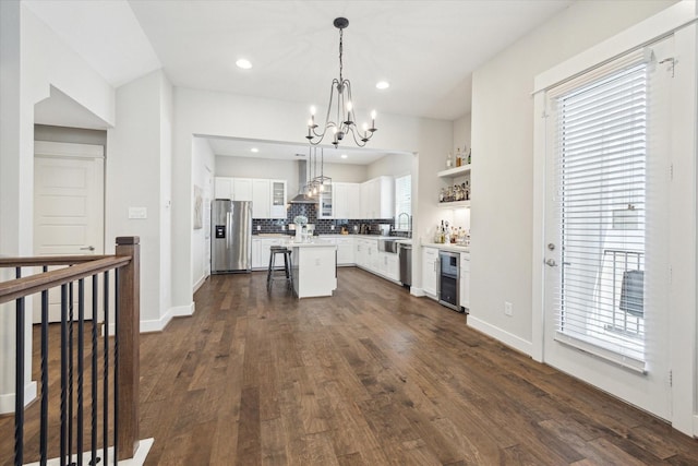 1226 W 17th St Unit E, Houston, TX 77008 - kitchen featuring stainless steel appliances, wine cooler, a chandelier, wall chimney exhaust hood, and a center island