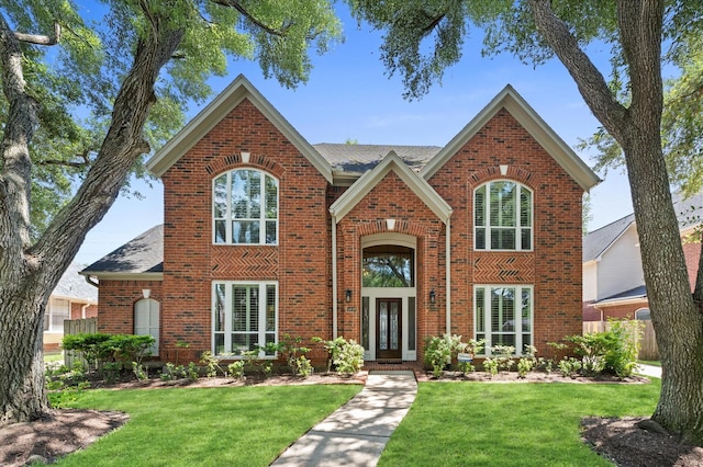5418 Brook Bend Dr, Sugar Land, TX 77479 - traditional home with brick siding, a front yard, french doors, and a shingled roof