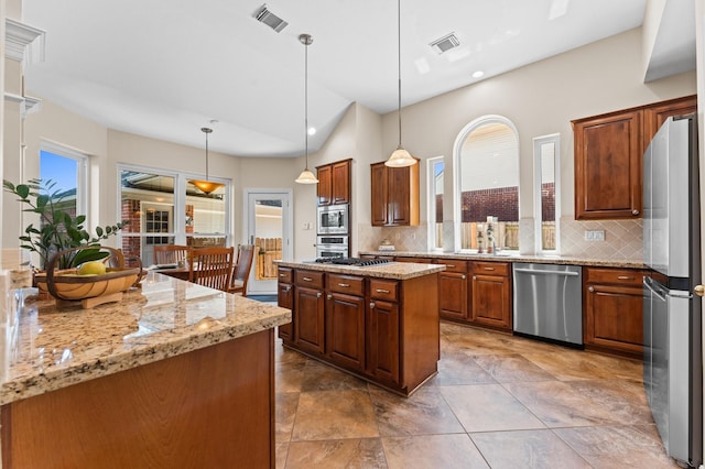 5418 Brook Bend Dr, Sugar Land, TX 77479 - kitchen with stainless steel appliances, backsplash, light stone countertops, a kitchen island, and vaulted ceiling