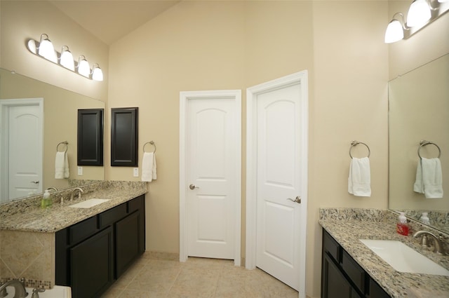 3411 Hawkins Glen Ln, Katy, TX 77449 - full bath featuring two vanities, tile patterned floors, high vaulted ceiling, and baseboards