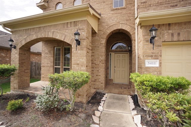 3411 Hawkins Glen Ln, Katy, TX 77449 - view of exterior entry featuring brick siding, a garage, and a porch
