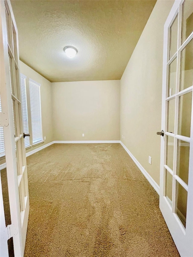 3411 Hawkins Glen Ln, Katy, TX 77449 - carpeted empty room with french doors, a textured ceiling, and baseboards