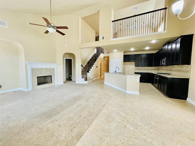 3411 Hawkins Glen Ln, Katy, TX 77449 - kitchen with dark cabinets, open floor plan, ceiling fan, a high ceiling, and baseboards