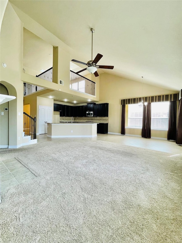 3411 Hawkins Glen Ln, Katy, TX 77449 - unfurnished living room featuring a ceiling fan, baseboards, light carpet, high vaulted ceiling, and stairs