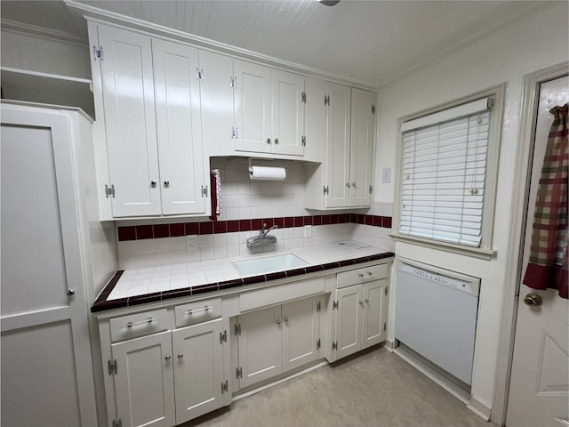 2105 12th St, Galena Park, TX 77547 - kitchen with dishwasher, tile countertops, backsplash, a sink, and white cabinetry