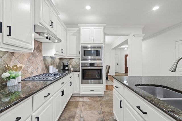 1117 Beall Landing Ct, Houston, TX 77008 - kitchen featuring appliances with stainless steel finishes, a sink, under cabinet range hood, white cabinets, and backsplash