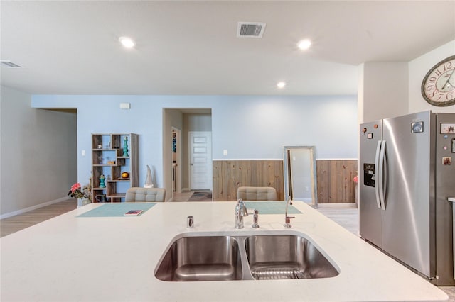 12917 S Winding Pines Dr, Tomball, TX 77375 - kitchen with stainless steel refrigerator with ice dispenser, a sink, open floor plan, light wood-type flooring, and wainscoting