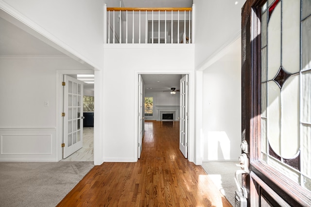 4402 Chipping Ct, Sugar Land, TX 77479 - entrance foyer featuring wood finished floors, a fireplace, a ceiling fan, ornamental molding, and wainscoting