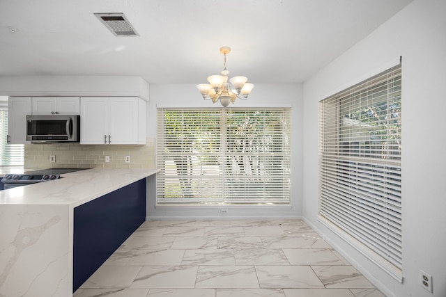 4402 Chipping Ct, Sugar Land, TX 77479 - kitchen featuring stainless steel microwave, a chandelier, white cabinetry, light stone countertops, and light marble finish floors