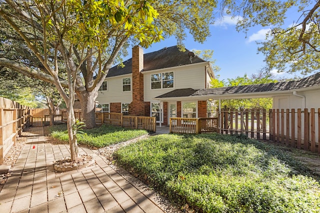 4402 Chipping Ct, Sugar Land, TX 77479 - rear view of house featuring a chimney, a wooden deck, a fenced backyard, and brick siding