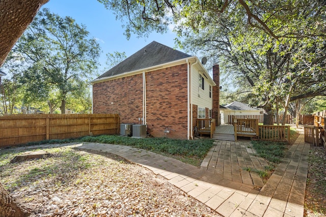 4402 Chipping Ct, Sugar Land, TX 77479 - view of home's exterior with brick siding, fence, a shingled roof, a deck, and a chimney