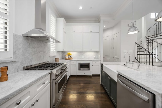 812 W Drew St, Houston, TX 77006 - kitchen with appliances with stainless steel finishes, wall chimney range hood, a sink, ornamental molding, and white cabinets