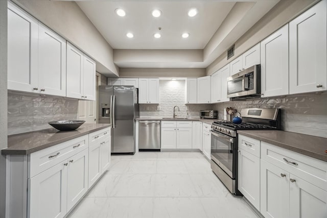 5905 Sugar Hill Dr Unit 221, Houston, TX 77057 - kitchen with stainless steel appliances, a sink, light marble finish floors, white cabinetry, and recessed lighting