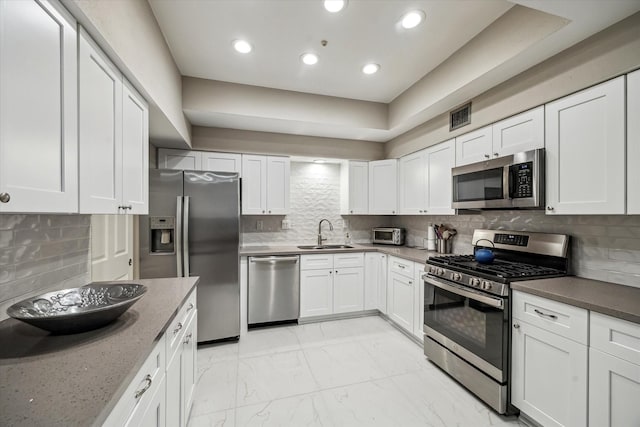 5905 Sugar Hill Dr Unit 221, Houston, TX 77057 - kitchen featuring appliances with stainless steel finishes, a sink, backsplash, white cabinets, and recessed lighting