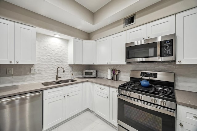 5905 Sugar Hill Dr Unit 221, Houston, TX 77057 - kitchen with stainless steel appliances, a sink, white cabinets, and backsplash