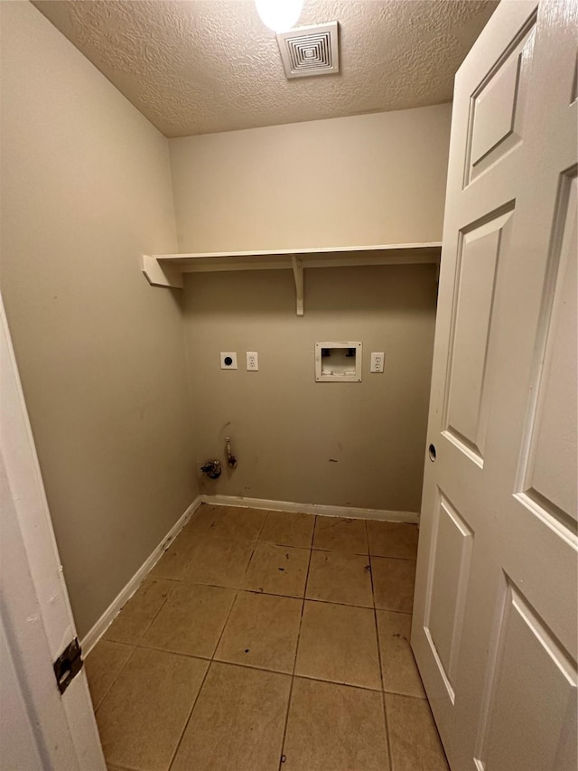 6723 Highwind Bend Ln, Katy, TX 77449 - laundry area featuring electric dryer hookup, hookup for a washing machine, a textured ceiling, tile patterned flooring, and baseboards