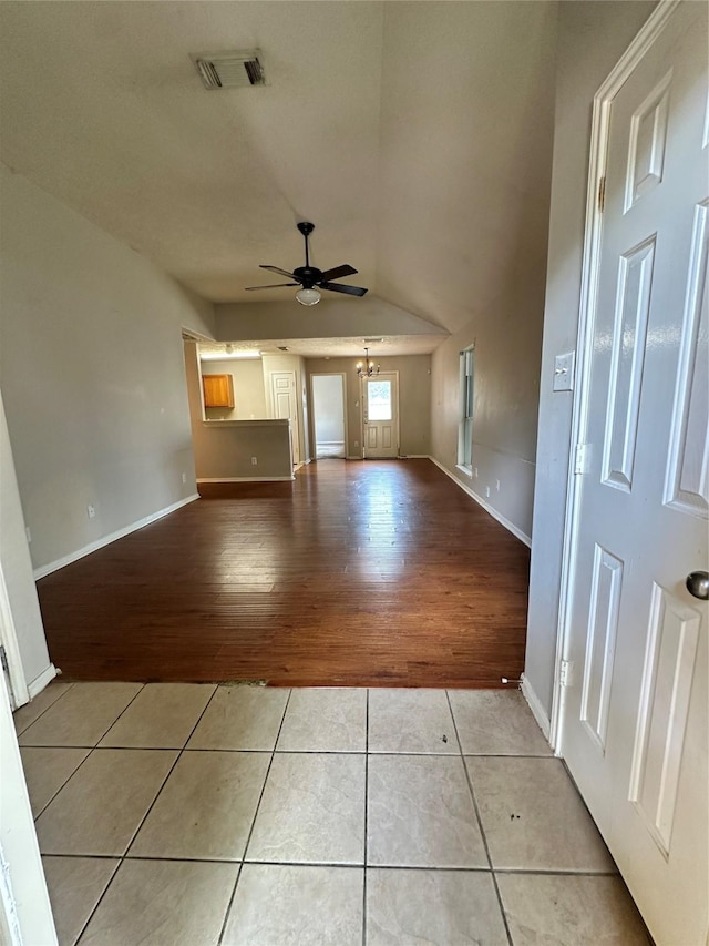 6723 Highwind Bend Ln, Katy, TX 77449 - unfurnished living room featuring ceiling fan, light tile patterned floors, vaulted ceiling, and baseboards