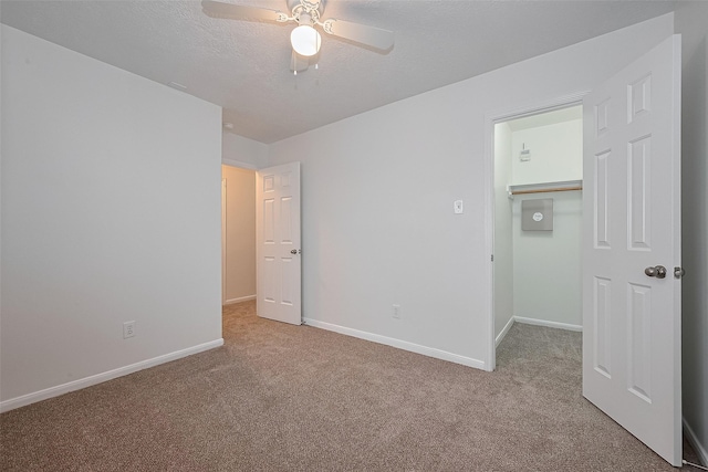 6723 Highwind Bend Ln, Katy, TX 77449 - unfurnished bedroom with carpet flooring, baseboards, a spacious closet, ceiling fan, and a textured ceiling