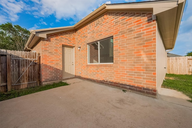 6723 Highwind Bend Ln, Katy, TX 77449 - doorway to property featuring brick siding, a patio area, and a gate