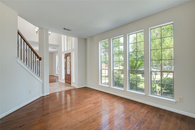 foyer entrance featuring plenty of natural light, hardwood / wood-style flooring, baseboards, and stairs